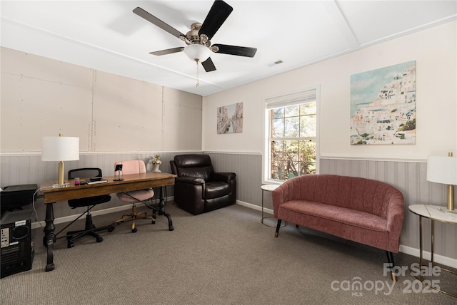 carpeted office space with ceiling fan