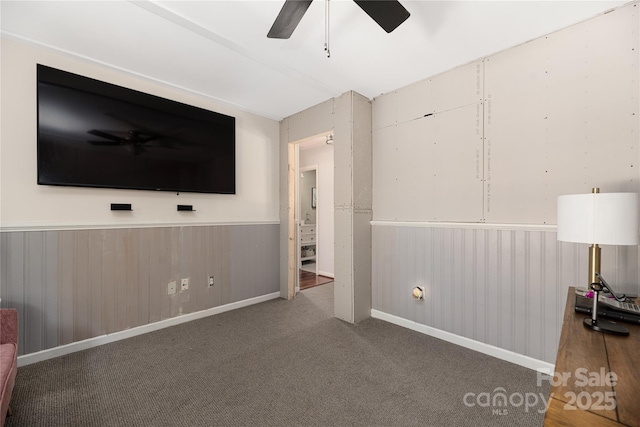 interior space with ceiling fan and wood walls