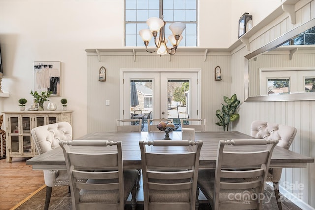 dining area featuring a notable chandelier, french doors, and hardwood / wood-style floors