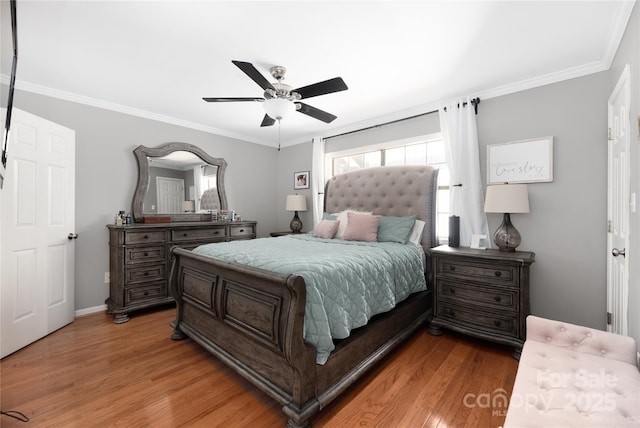 bedroom featuring ceiling fan, ornamental molding, and light hardwood / wood-style flooring