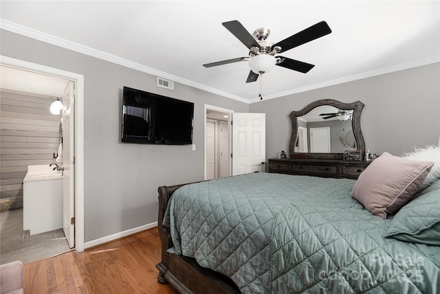 bedroom featuring ceiling fan, crown molding, ensuite bath, and wood-type flooring