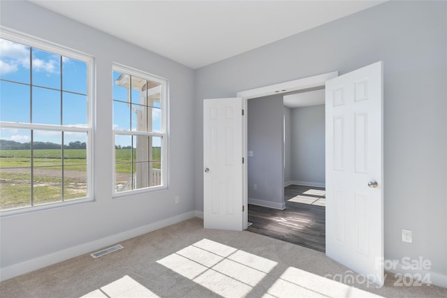 unfurnished bedroom featuring a rural view and light hardwood / wood-style flooring