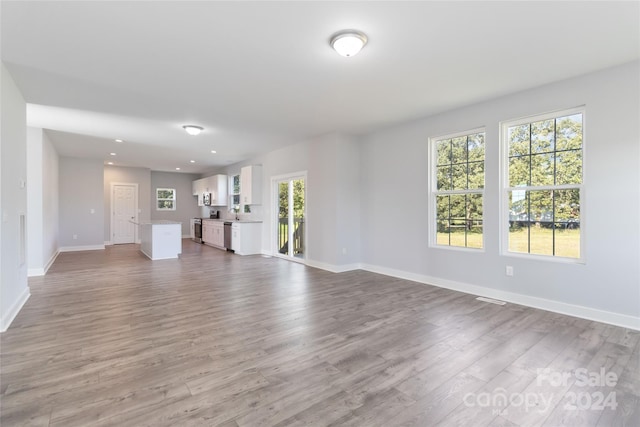 unfurnished living room with plenty of natural light and hardwood / wood-style flooring