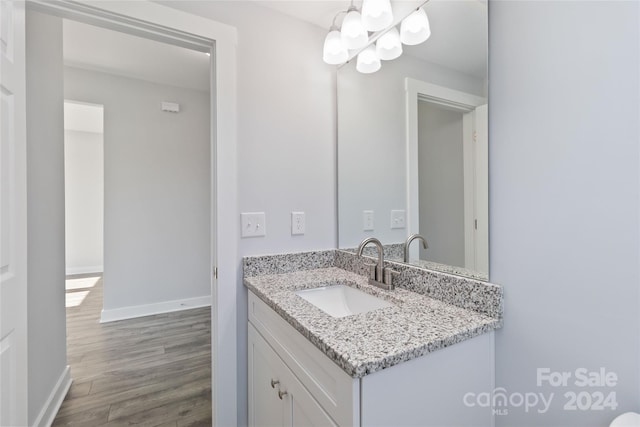 bathroom featuring a notable chandelier, hardwood / wood-style flooring, and vanity