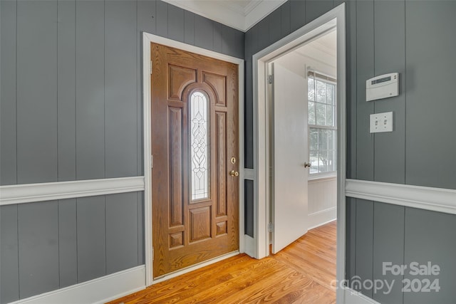 entryway featuring ornamental molding and light hardwood / wood-style floors