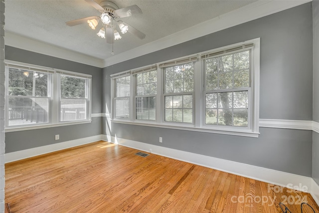 empty room featuring a textured ceiling, crown molding, ceiling fan, and hardwood / wood-style flooring