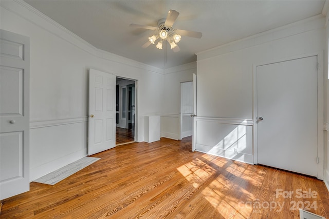 unfurnished bedroom featuring light wood-type flooring, ornamental molding, and ceiling fan