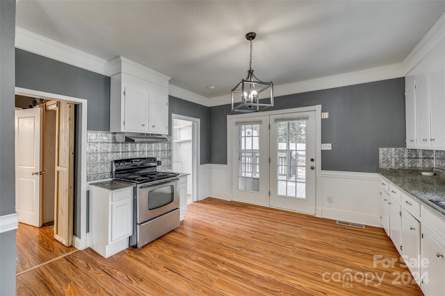 kitchen with pendant lighting, light hardwood / wood-style floors, white cabinetry, decorative backsplash, and stainless steel electric stove