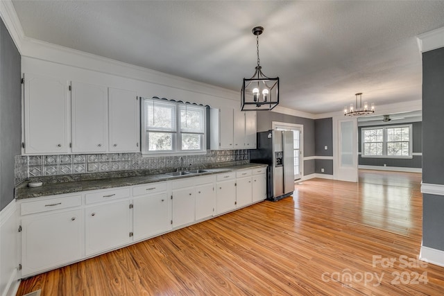 kitchen featuring white cabinets, stainless steel refrigerator with ice dispenser, and a healthy amount of sunlight