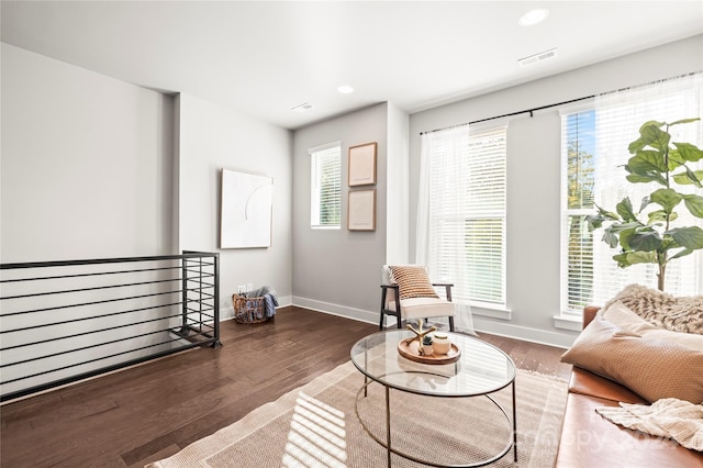 living area featuring a healthy amount of sunlight and dark hardwood / wood-style floors