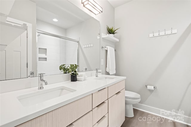 bathroom with walk in shower, vanity, toilet, and wood-type flooring