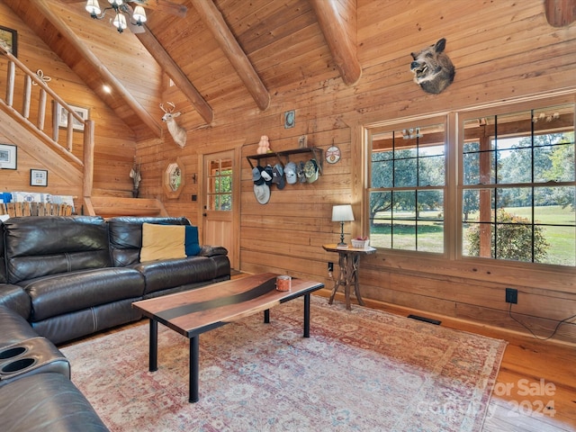 living room with wood-type flooring, wooden walls, vaulted ceiling with beams, and a wealth of natural light