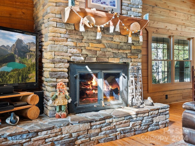 details with a fireplace, wood walls, and wood-type flooring