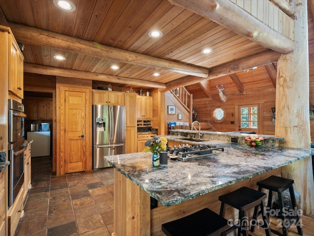 kitchen featuring wooden walls, appliances with stainless steel finishes, kitchen peninsula, and wooden ceiling