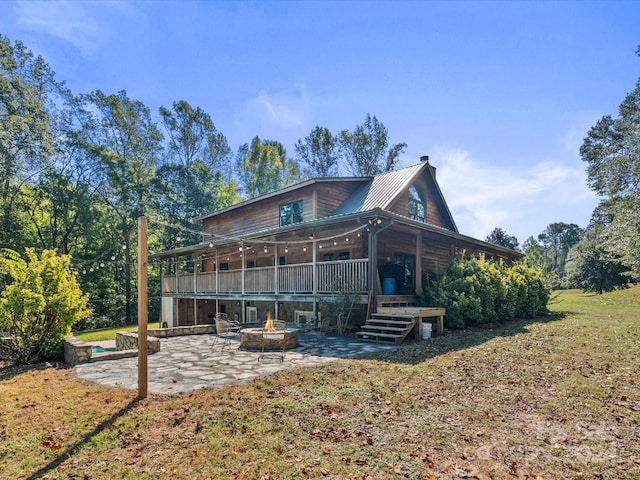 rear view of house featuring an outdoor fire pit, a yard, and a patio