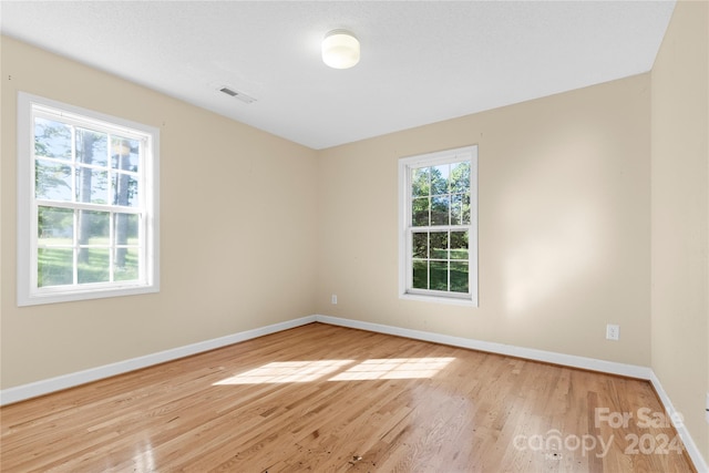 unfurnished room with plenty of natural light and light hardwood / wood-style flooring