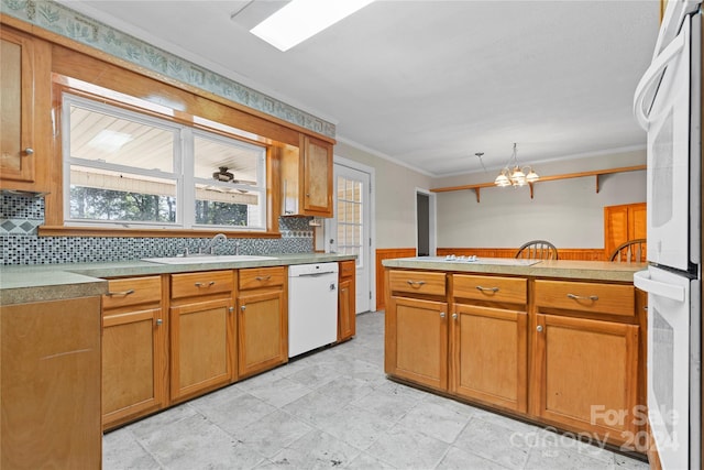 kitchen featuring decorative backsplash, white appliances, an inviting chandelier, and sink