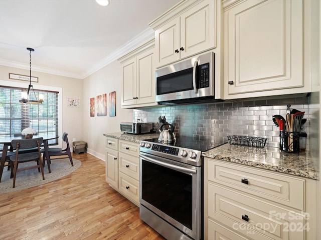 kitchen with a chandelier, crown molding, light hardwood / wood-style flooring, cream cabinetry, and stainless steel appliances