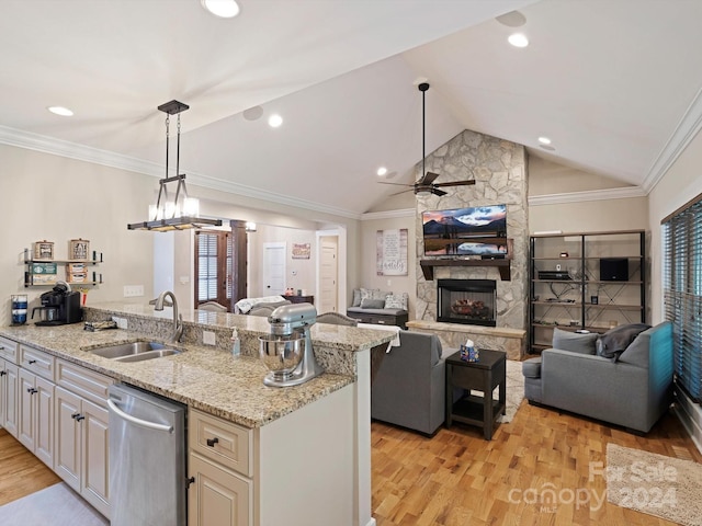 kitchen with lofted ceiling, light stone counters, stainless steel dishwasher, sink, and light hardwood / wood-style floors