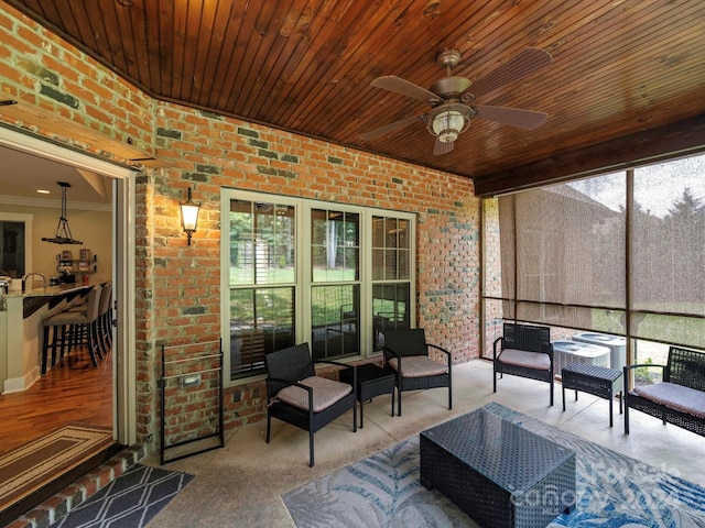 sunroom featuring ceiling fan and wood ceiling