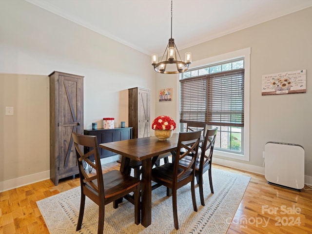 dining area with crown molding, plenty of natural light, a chandelier, and light hardwood / wood-style flooring