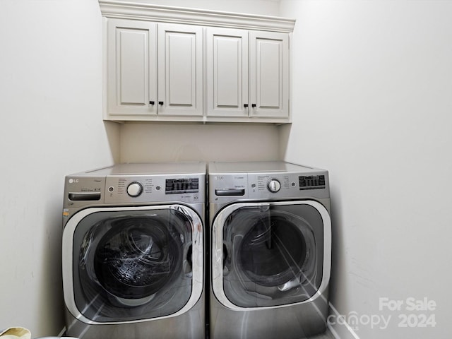 laundry room with washer and clothes dryer and cabinets