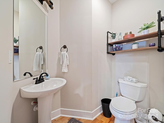 bathroom featuring wood-type flooring and toilet