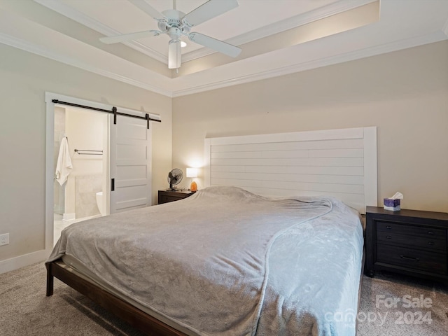 bedroom with ceiling fan, crown molding, a barn door, ensuite bathroom, and carpet flooring