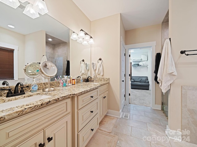 bathroom with tile patterned floors, vanity, and tiled shower