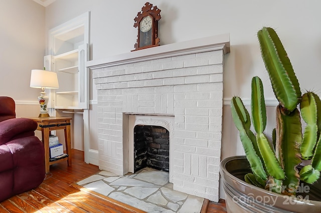 interior details featuring a brick fireplace and hardwood / wood-style floors