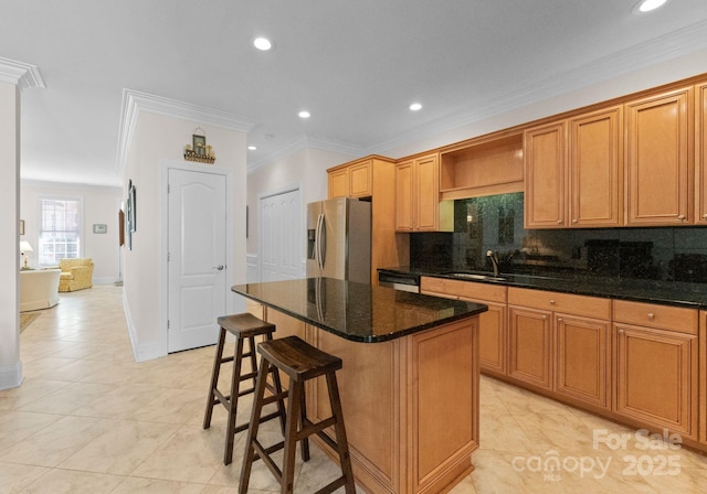 kitchen featuring a center island, sink, stainless steel appliances, crown molding, and dark stone counters