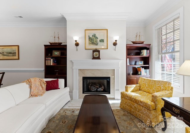 living room with a high end fireplace and ornamental molding