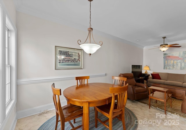 dining space featuring ceiling fan and crown molding