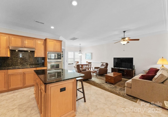 kitchen with stainless steel appliances, backsplash, crown molding, pendant lighting, and a kitchen island