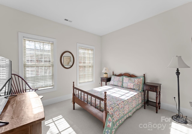 bedroom with light carpet and multiple windows