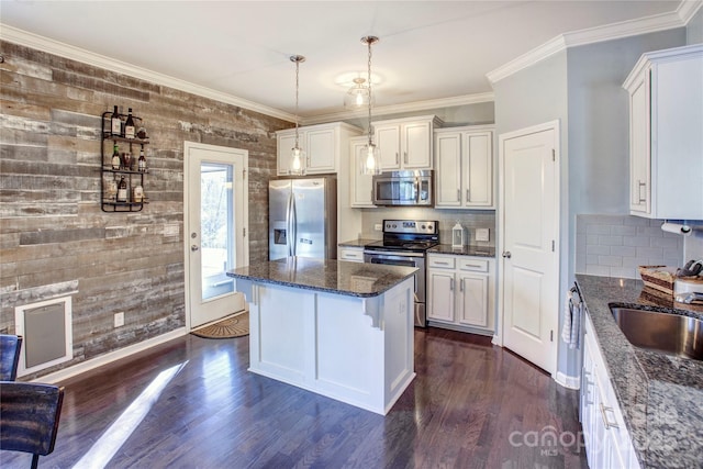 kitchen with pendant lighting, a breakfast bar area, white cabinetry, stainless steel appliances, and decorative backsplash