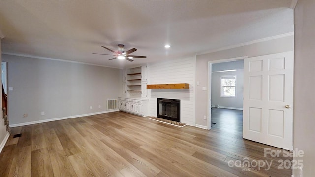 unfurnished living room featuring a large fireplace, baseboards, light wood-type flooring, visible vents, and ornamental molding