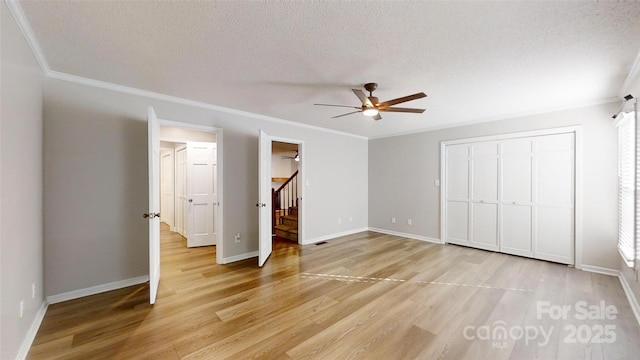 unfurnished bedroom with crown molding, a textured ceiling, and wood finished floors