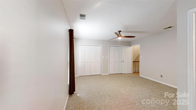 hallway with carpet flooring, baseboards, and visible vents