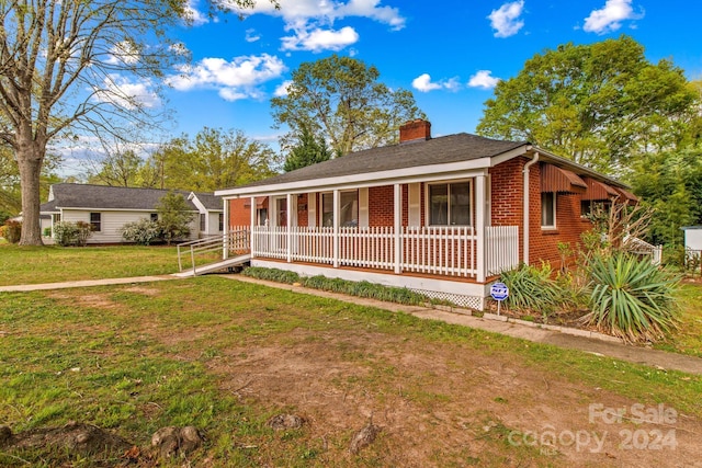 single story home with a front lawn and covered porch