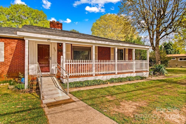 ranch-style home featuring a porch and a front yard