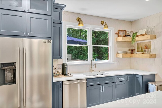 kitchen featuring stainless steel appliances, backsplash, and sink