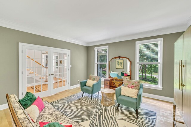 living area with french doors, light hardwood / wood-style floors, and ornamental molding