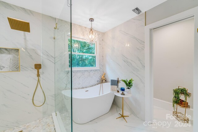 bathroom with separate shower and tub, tile walls, and a chandelier