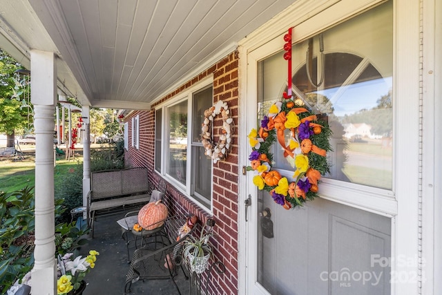 view of exterior entry featuring covered porch