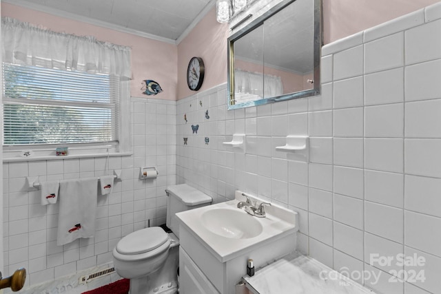 bathroom with toilet, vanity, and tile walls