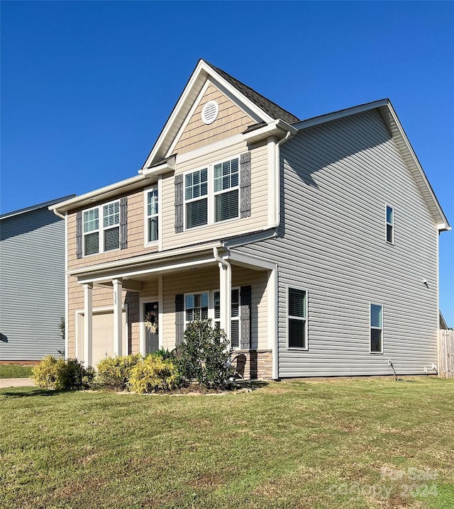 view of front of home with a front yard and a garage