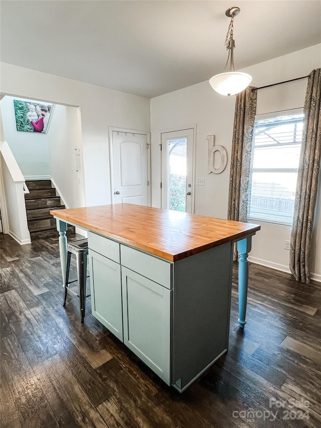 kitchen featuring dark wood-type flooring, pendant lighting, butcher block countertops, and a healthy amount of sunlight