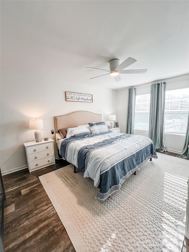 bedroom with dark hardwood / wood-style flooring and ceiling fan