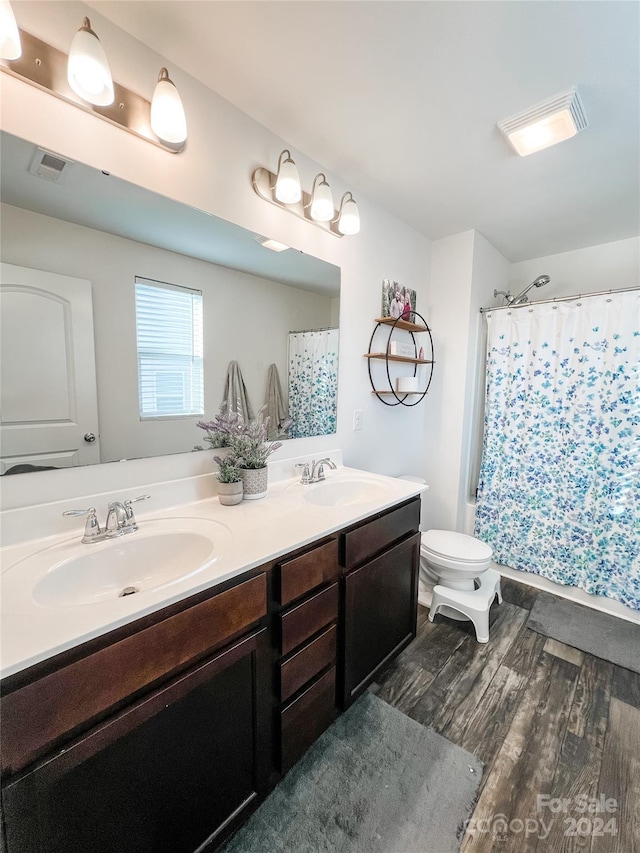 bathroom with a shower with shower curtain, vanity, hardwood / wood-style flooring, and toilet